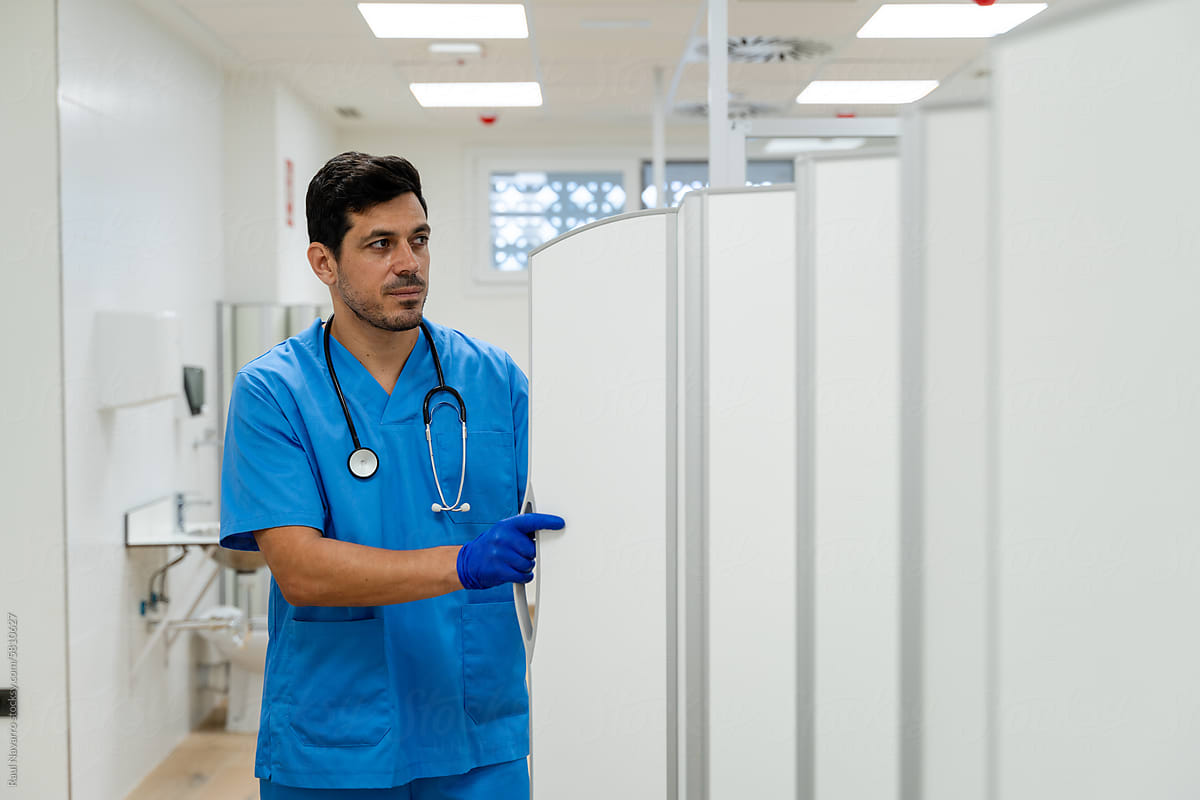 Portrait of male doctor standing in corridor of hospital
