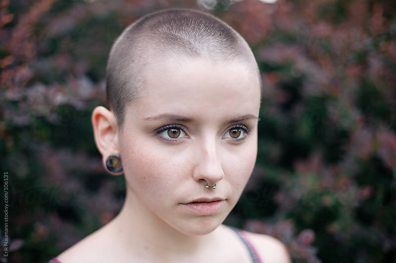 A Girl With A Shaved Head And Red Bushes In The Background By Erik