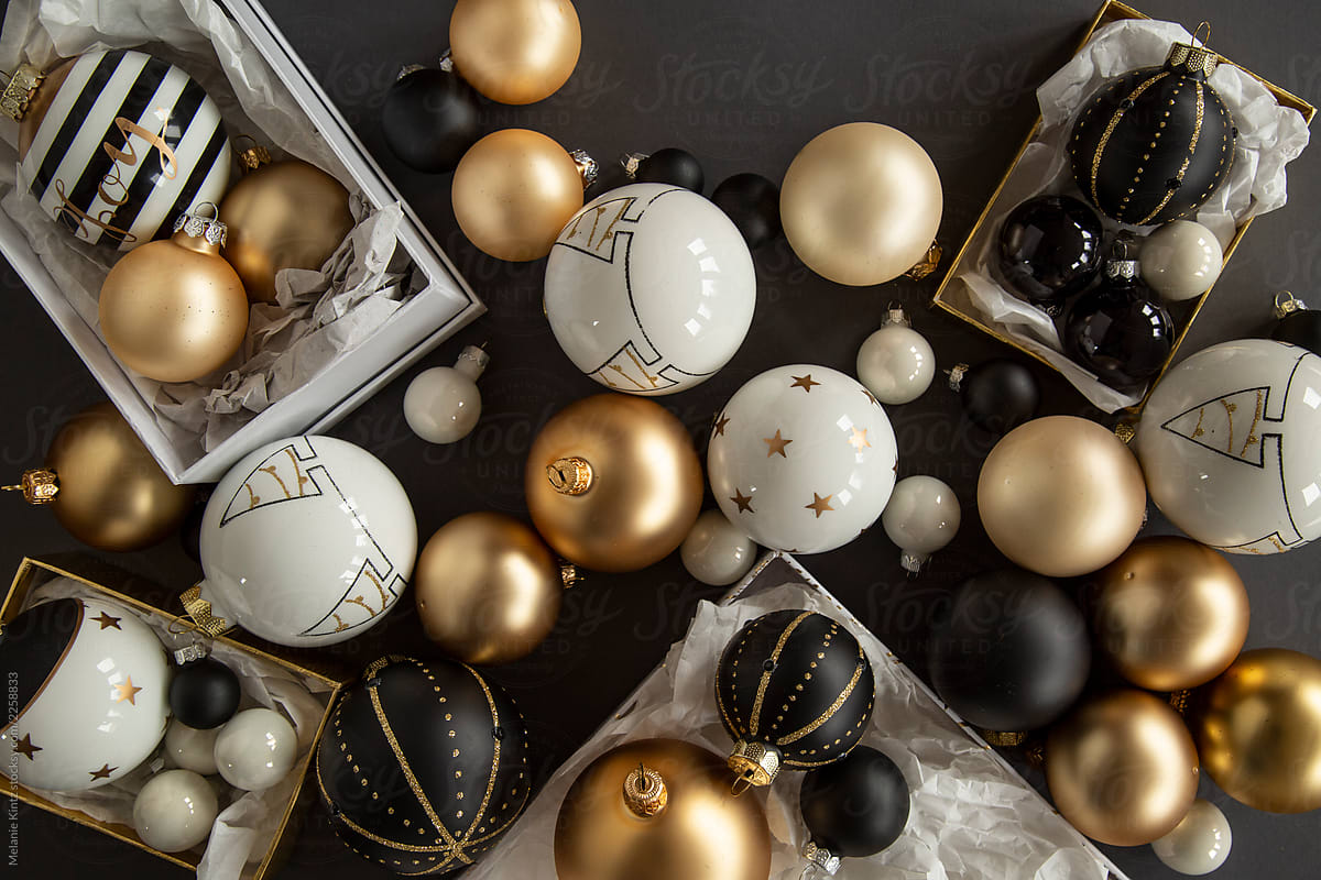 Black, white and gold Christmas ornaments on grey background