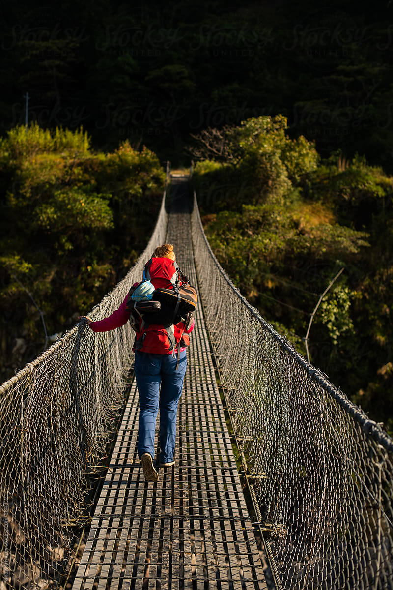 Young tourist woman crosses the suspension bridge in Nepal