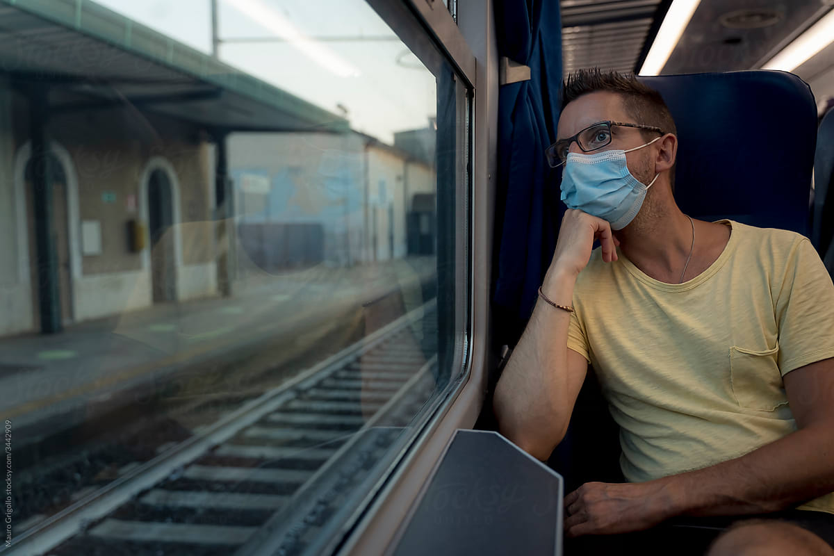 A man traveling by train and wearing a surgical mask during the Covid-19 crisis