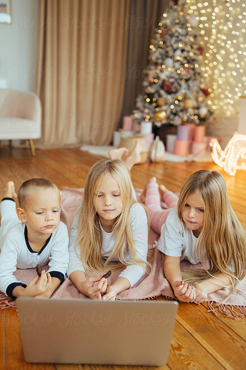 lovely kids watching movie on laptop at christmas