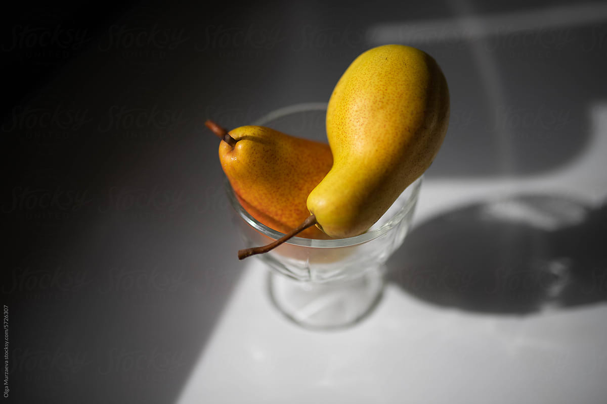 two yellow  pears in the glass vase