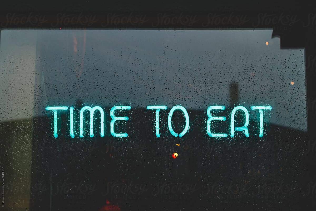 neon time to eat sign in window