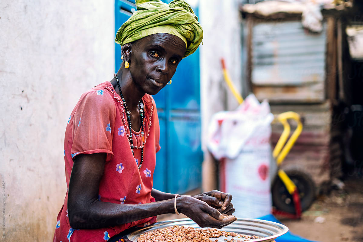 African woman sorting chickpea on market