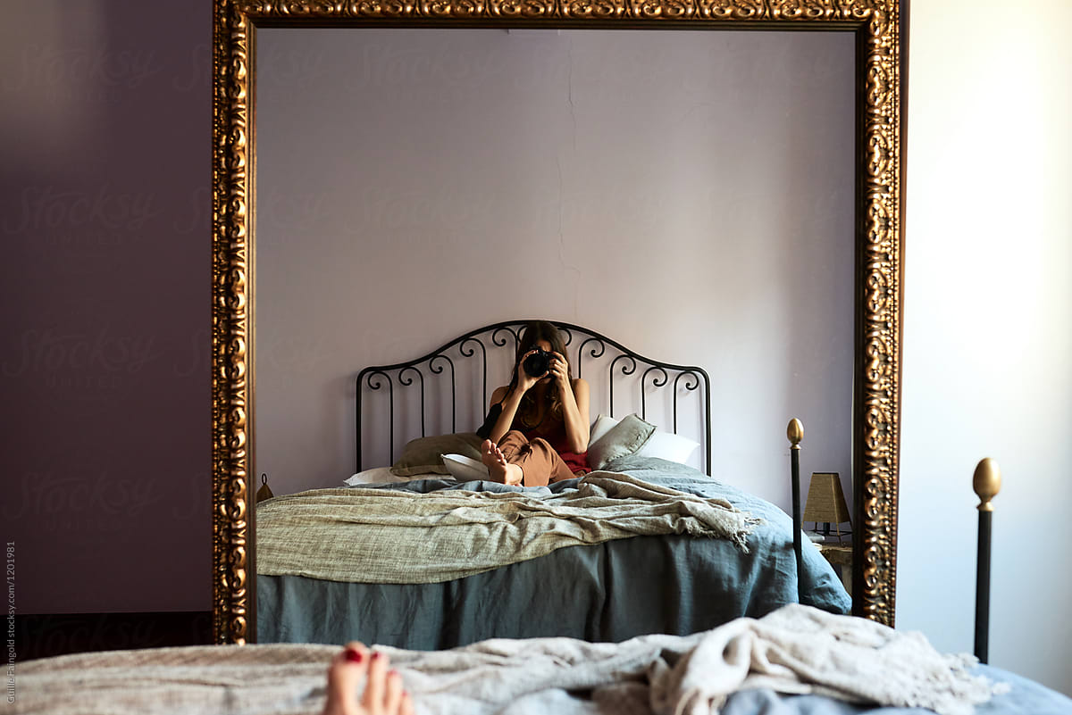 Woman Sitting On Bed Taking Selfie In Mirror By Guille Faingold 
