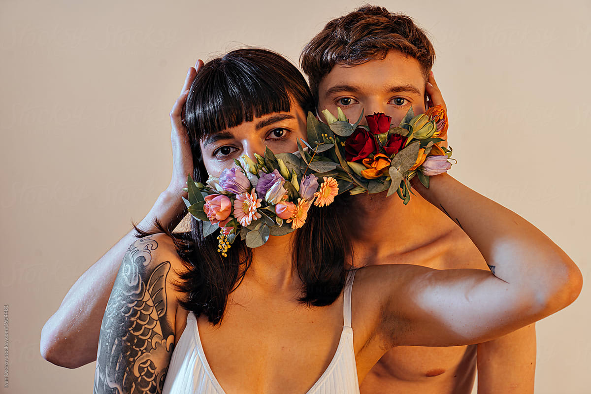 couple in love in protective flower masks in studio