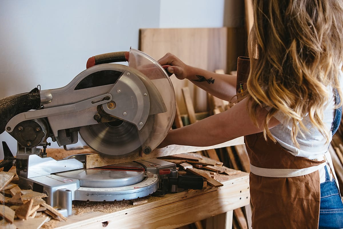 Wood making artist using a chop saw in her studio