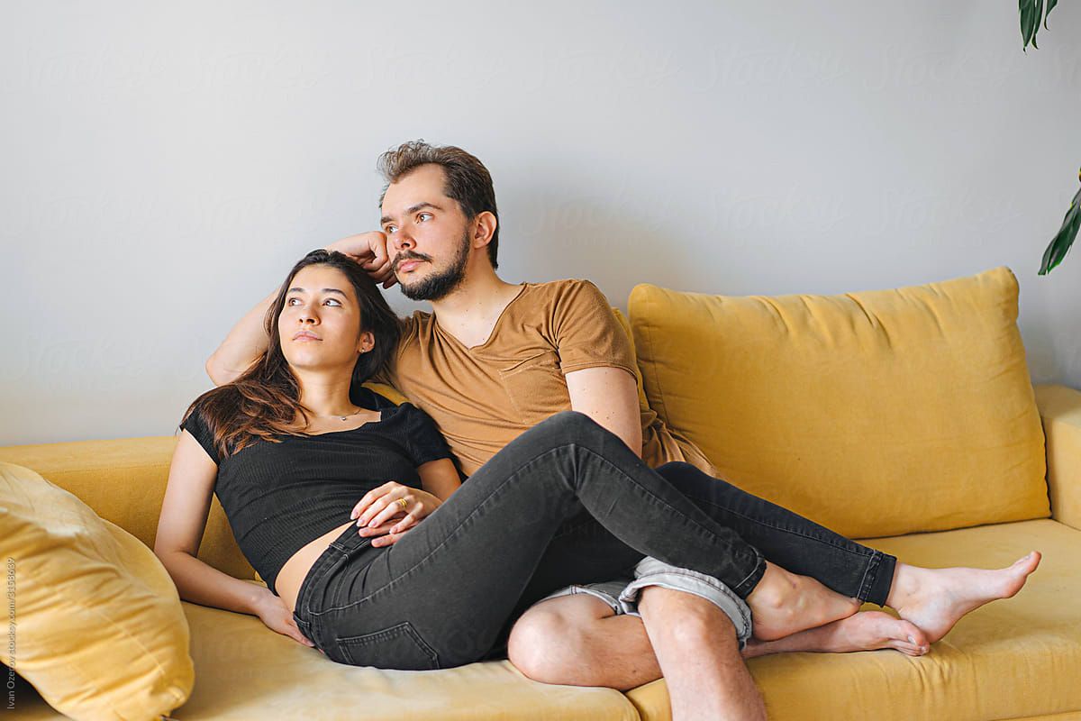 young couple sitting on a sofa in their apartment