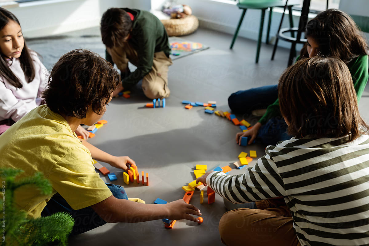 Kids playing with dominoes at playroom floor