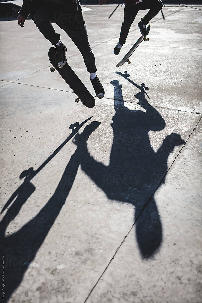 Shadow of Two Skateboarders Jumping at the Skatepark