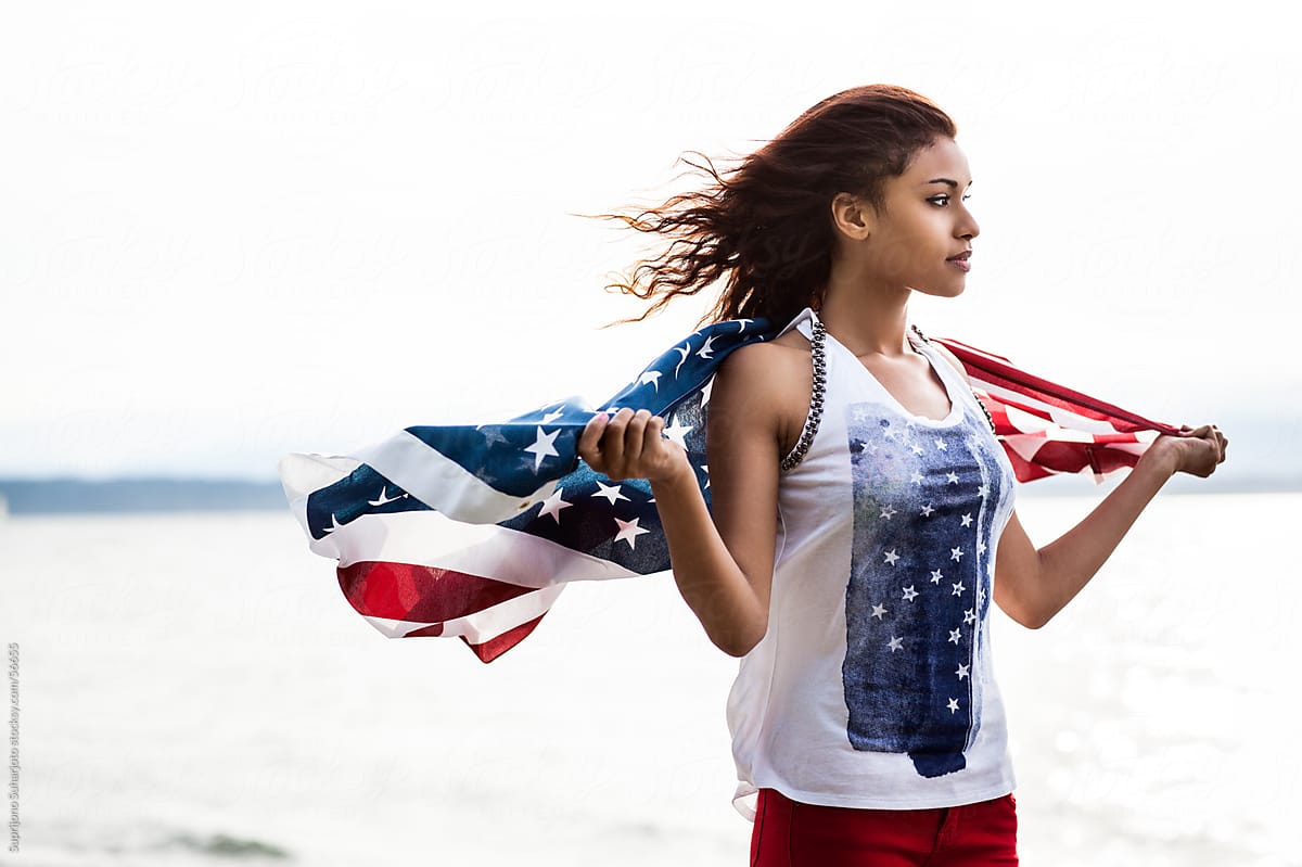 Beautiful young African American woman holding an American flag