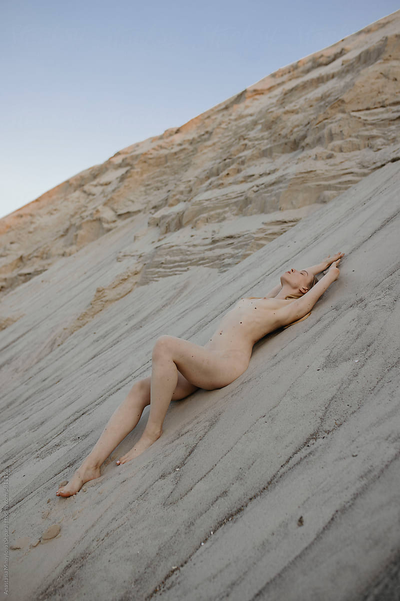 Naked natural blonde woman in nature on the sand