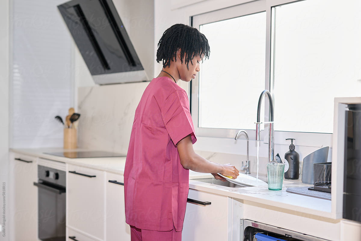 Nurse in uniform working at home doing housework