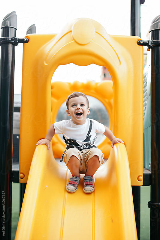 Happy kid playing on the slide.