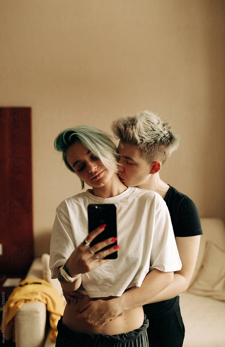 lesbian couple taking selfies in the mirror