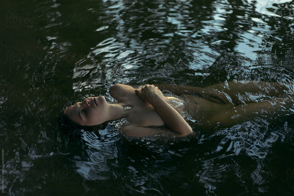 portrait of a girl without clothes in glowing water