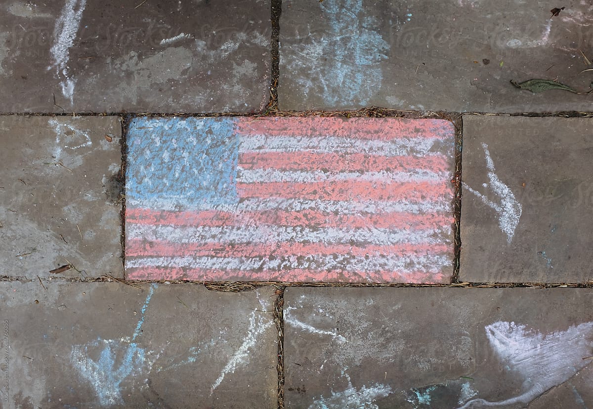 An American Flag on a sidewalk.