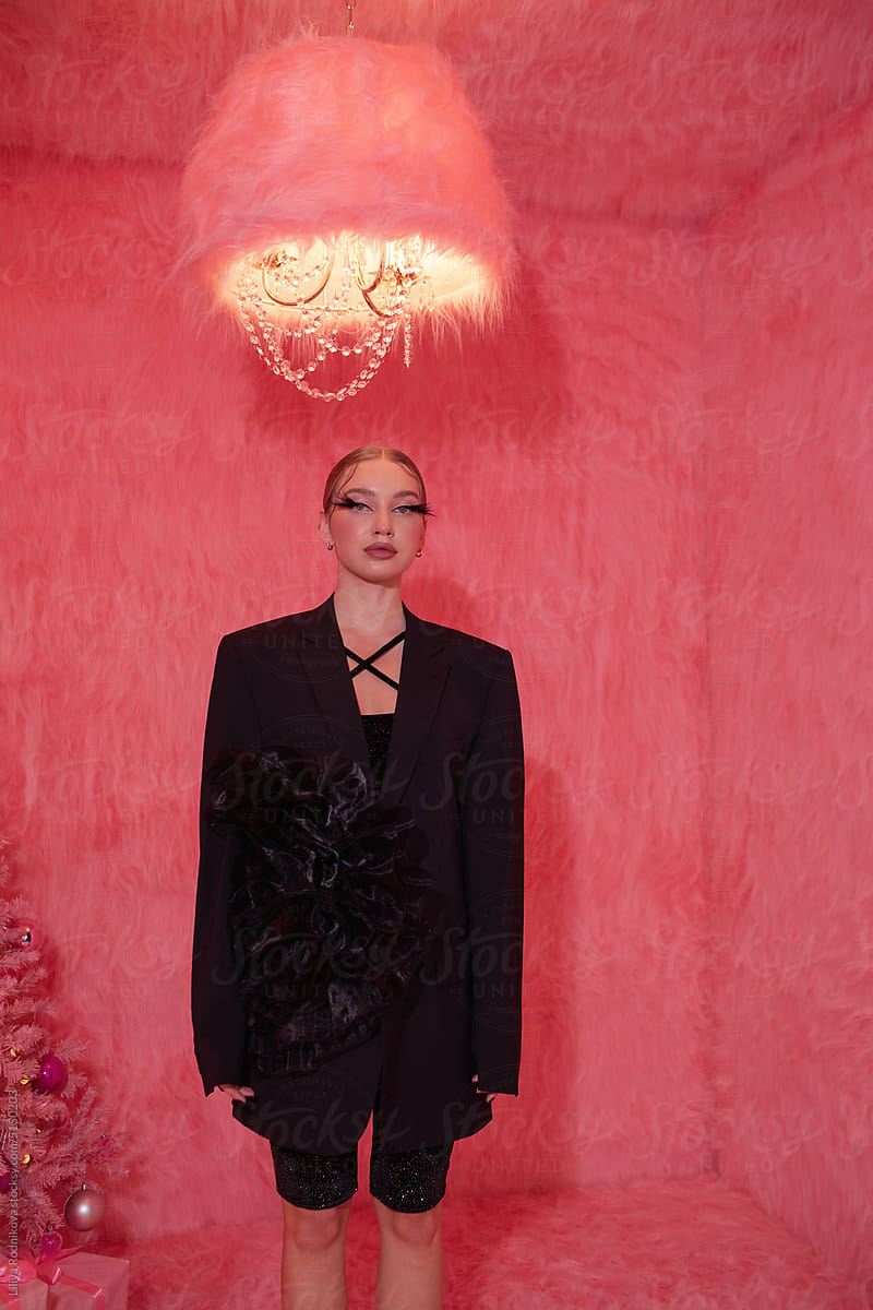 Woman in black standing in pink room with Christmas tree