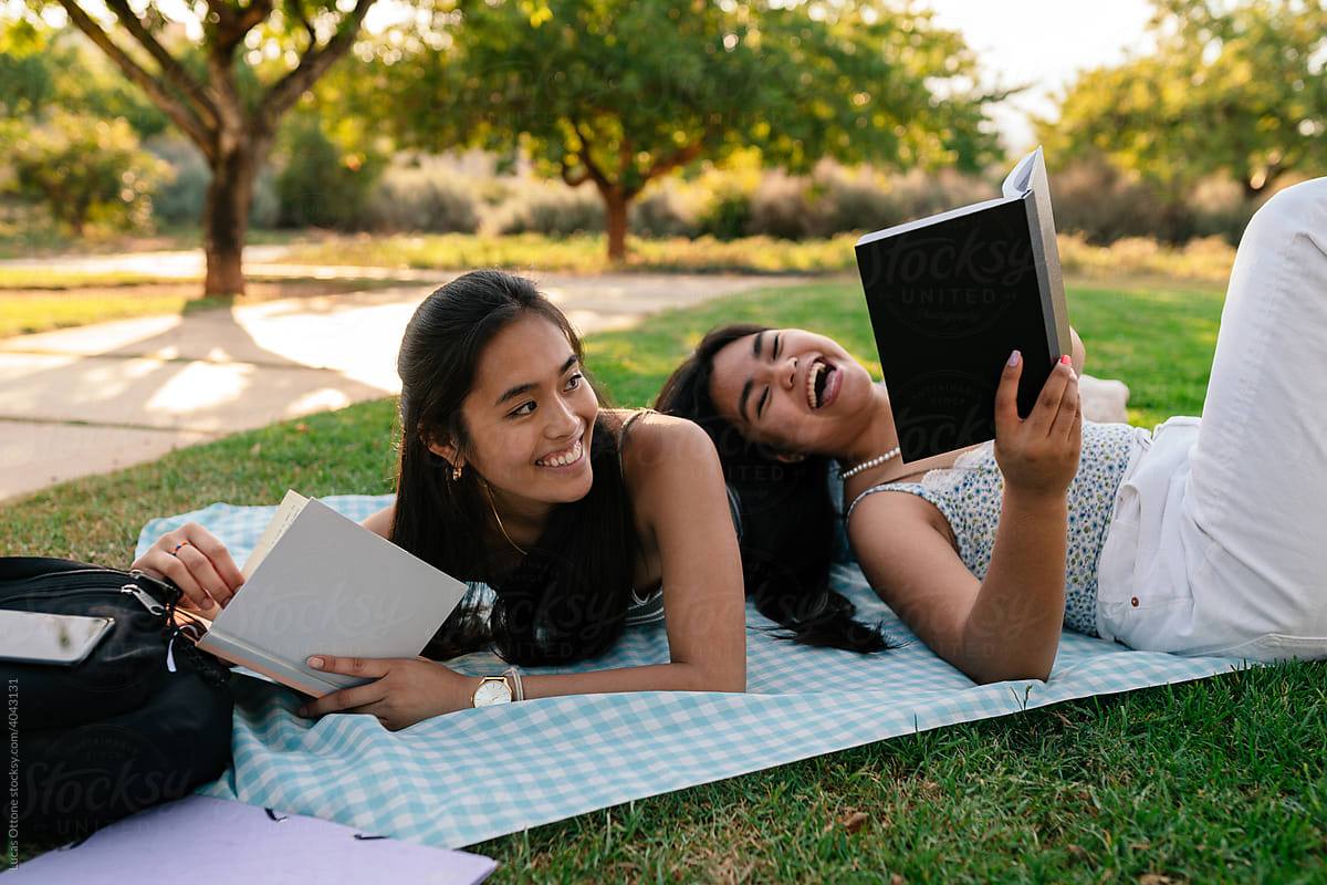 Two Asian students reading in the park