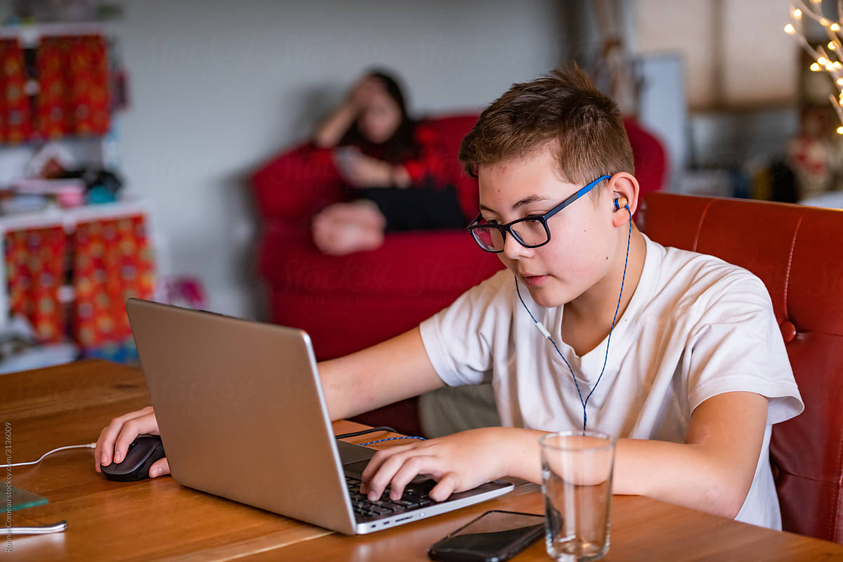 Teen Boy Online Gaming on Laptop at Home