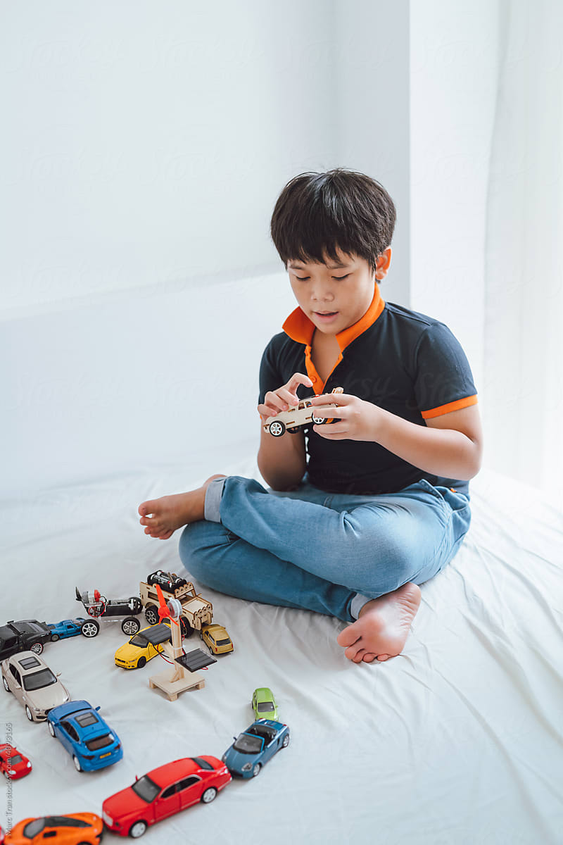 Boy playing wooden car model with solar panels
