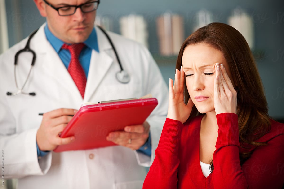Exam Room: Woman Rubs Head to Ease Migraine Pain