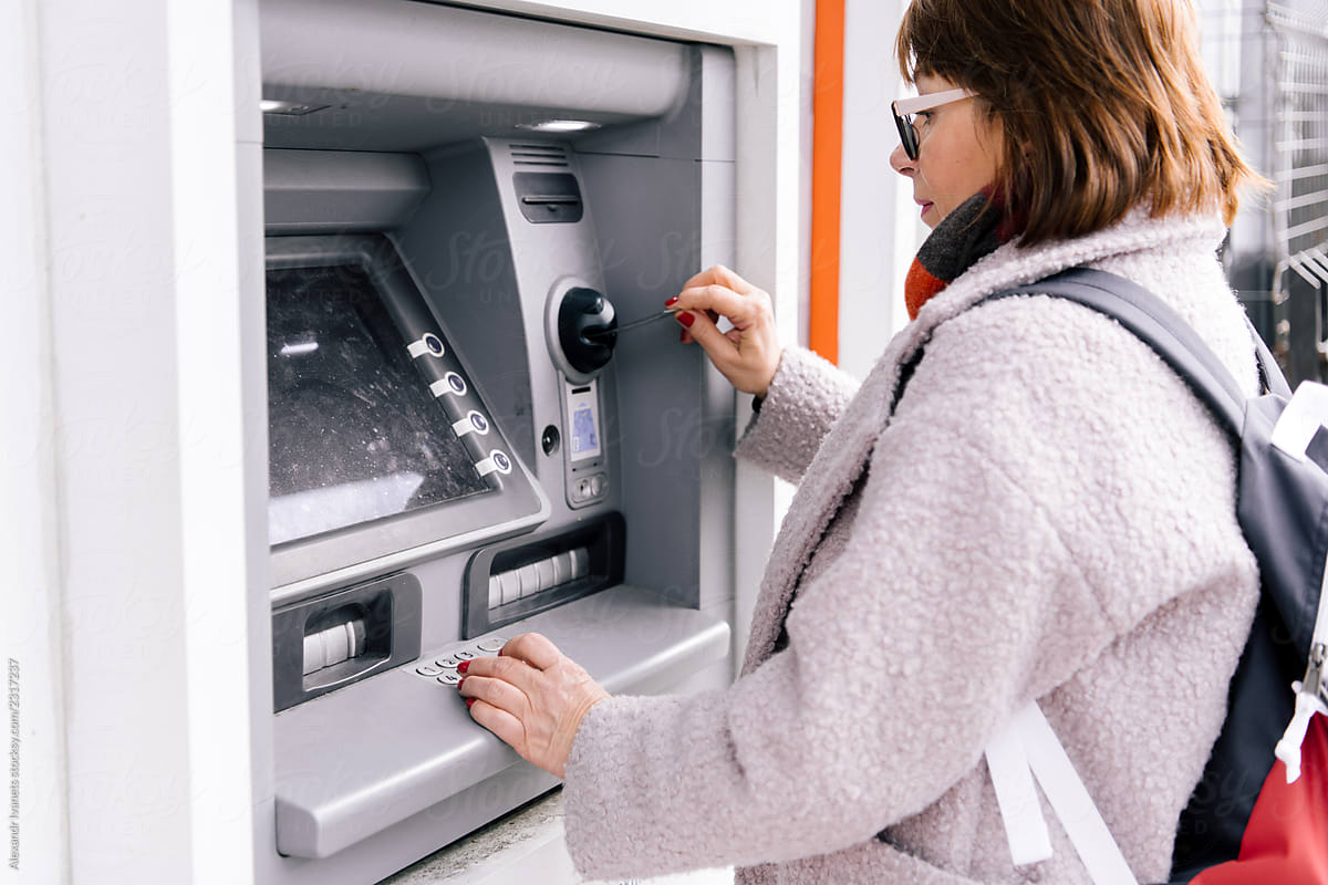 Adult female using ATM on street