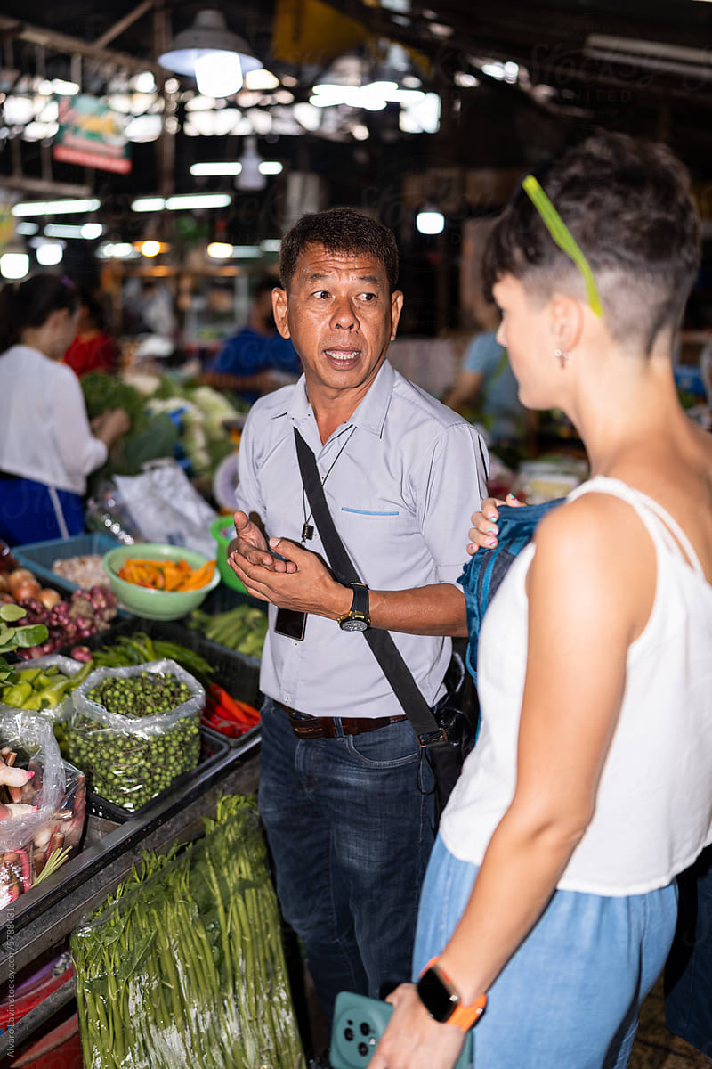 Male guide with a tourist in a market.