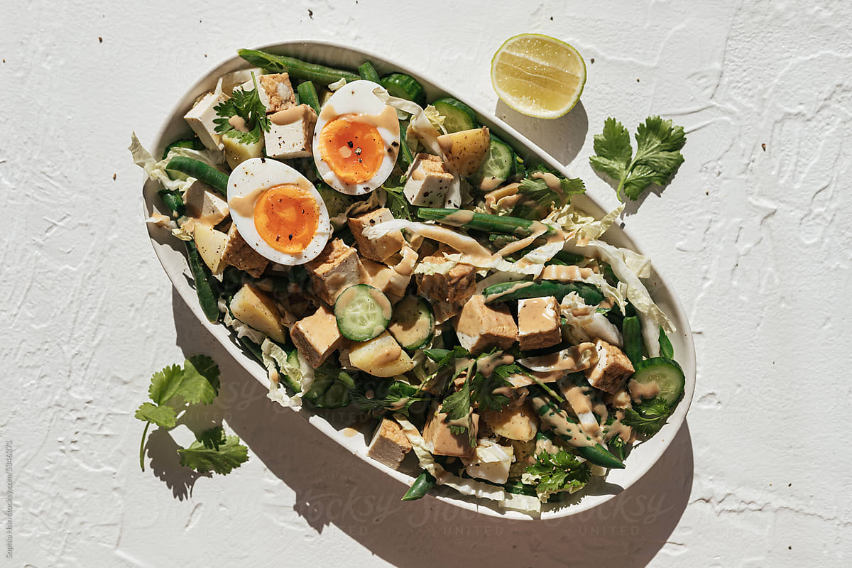 Healthy summer salad with eggs, tofu, cabbage, beans and peanut sauce