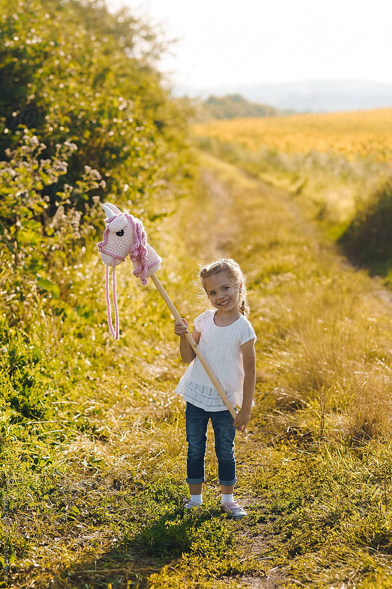 Little girl playing with unicorn toy.