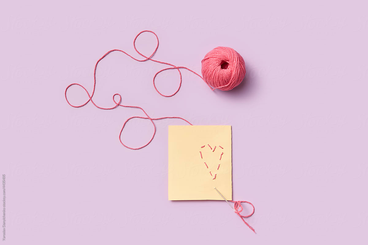 Greeting card with red heart made of thread sticks