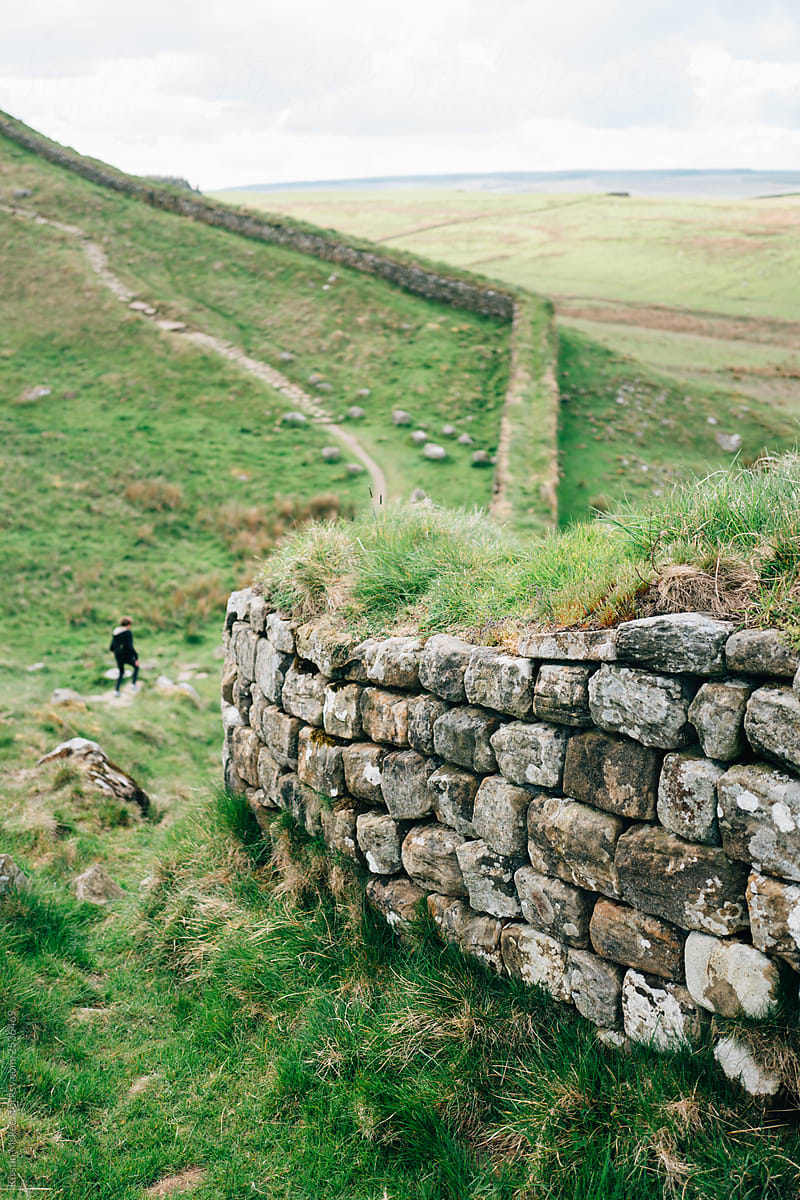 Boy running down path alongside Hadrian\'s wall