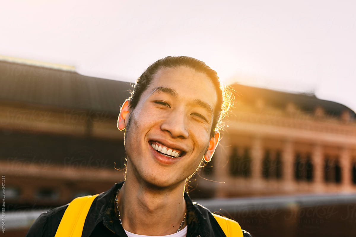 Happy handsome asian young man looking at camera
