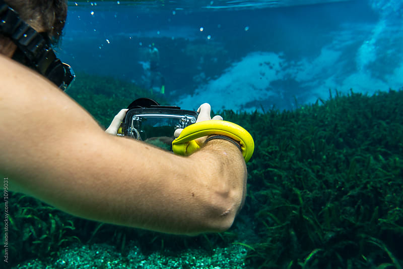 A snorkeler using a smartphone camera underwater