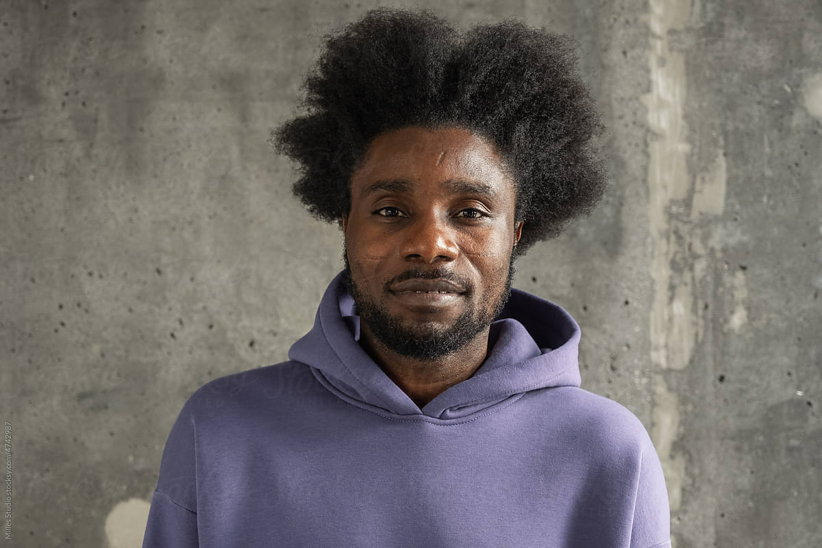 Black male in hoodie near concrete wall