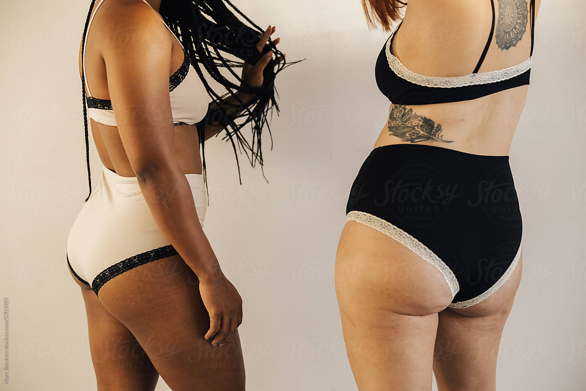 cropped image of the backs of two women dressed in underwear