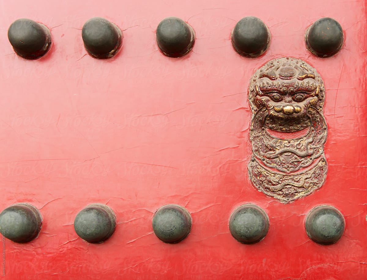 Lion head doorknob on red gate of Forbidden Palace in Bejing China