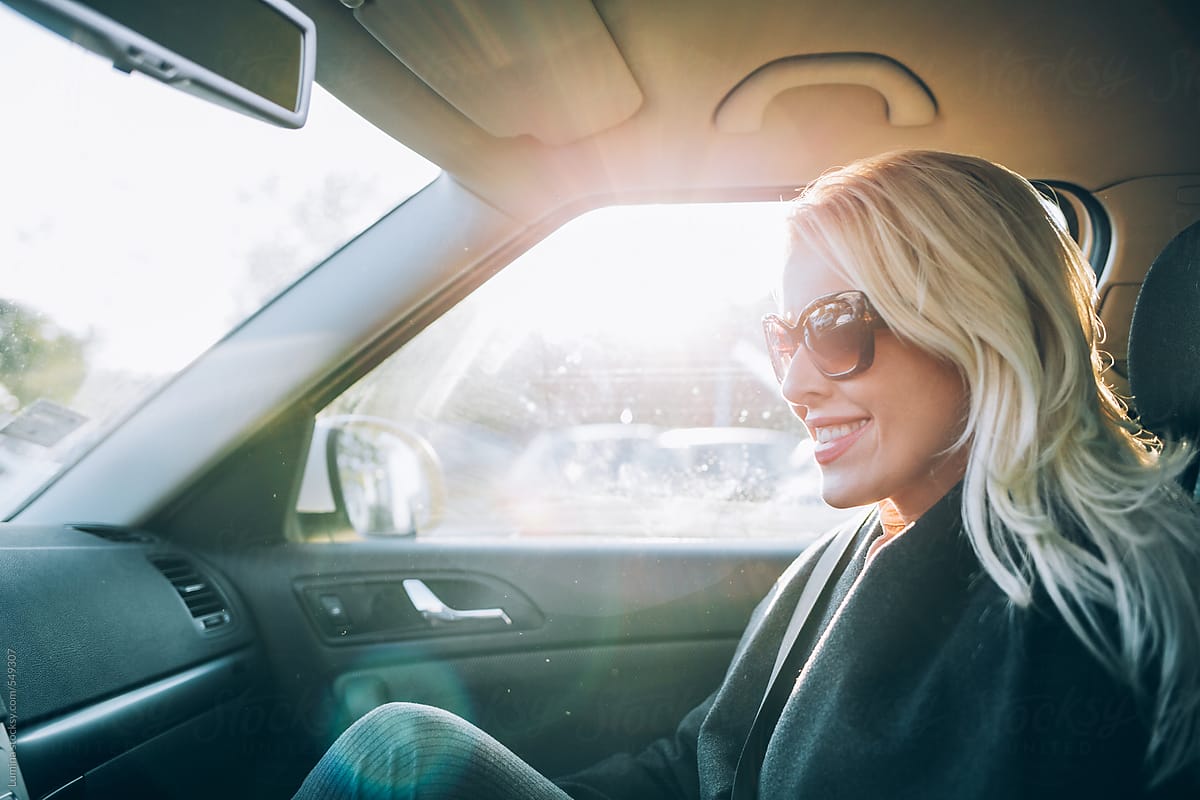 Smiling Blonde Woman In A Car Del Colaborador De Stocksy Lumina