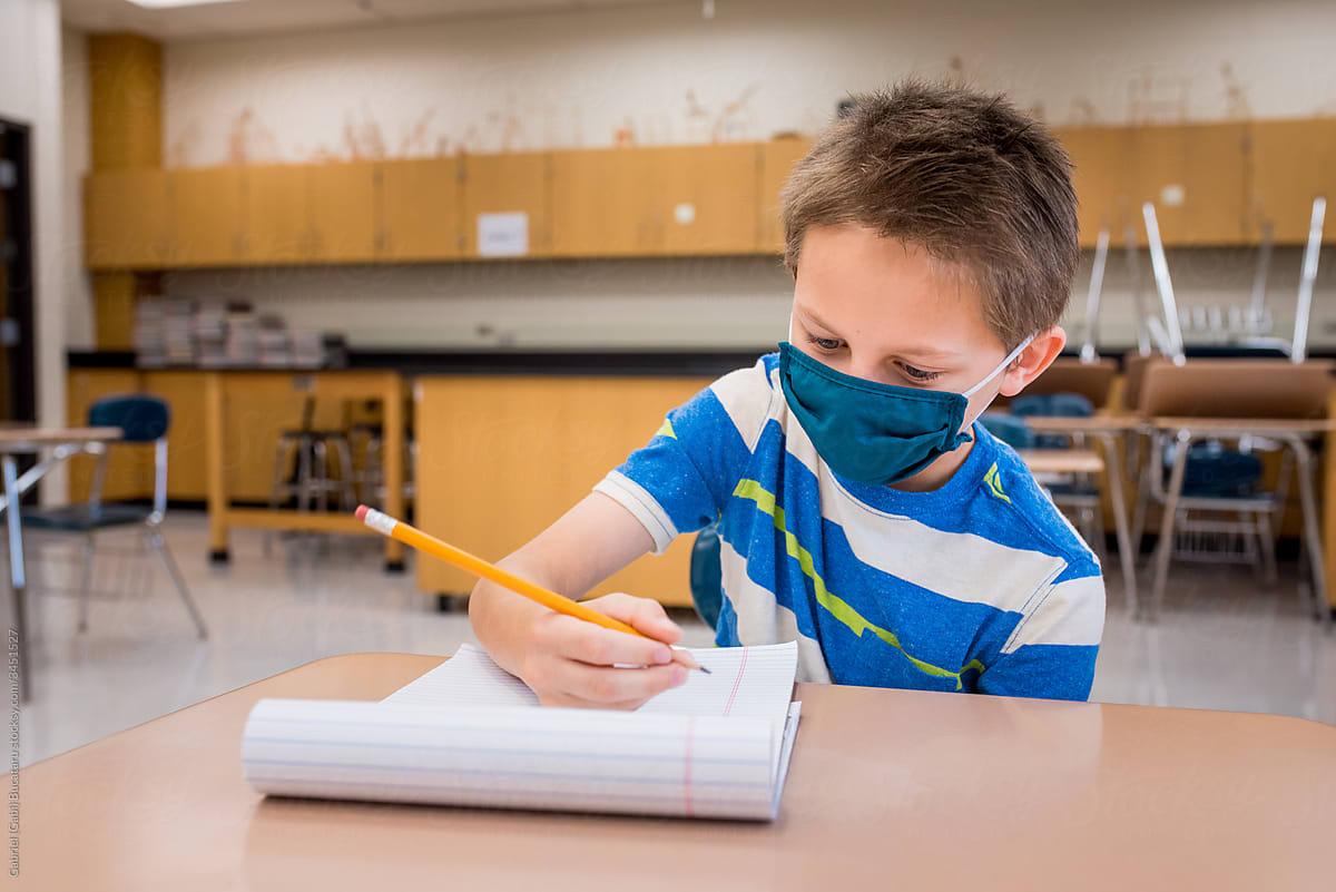 Boy wearing a mask in a classroom during covid-19
