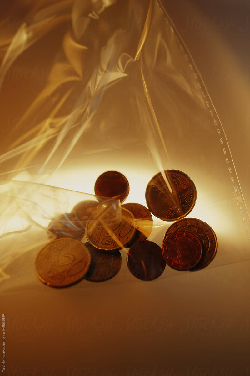 Euro coins in a plastic bag in golden light, still life