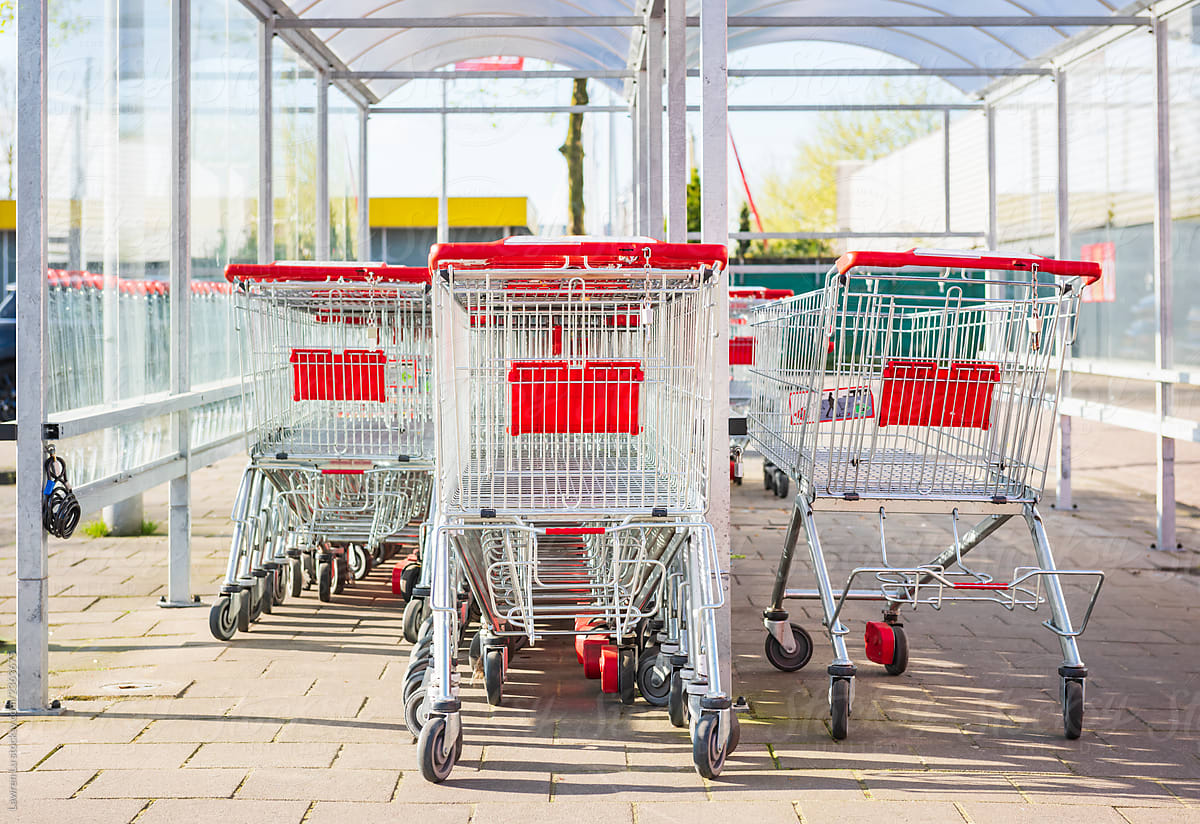 Row of supermarket shopping trolleys under awning