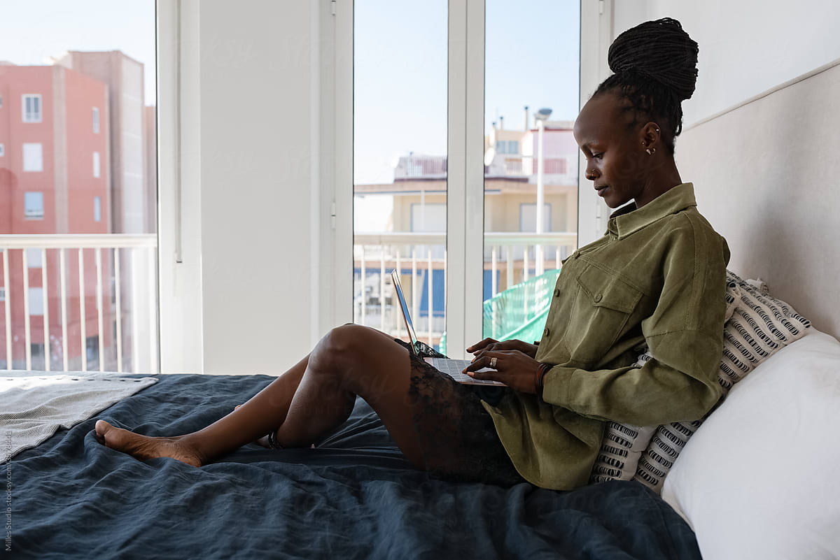 African freelancer using netbook against window