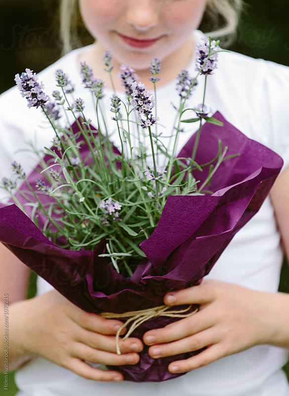 A child holding a gift of a Lavender plant.