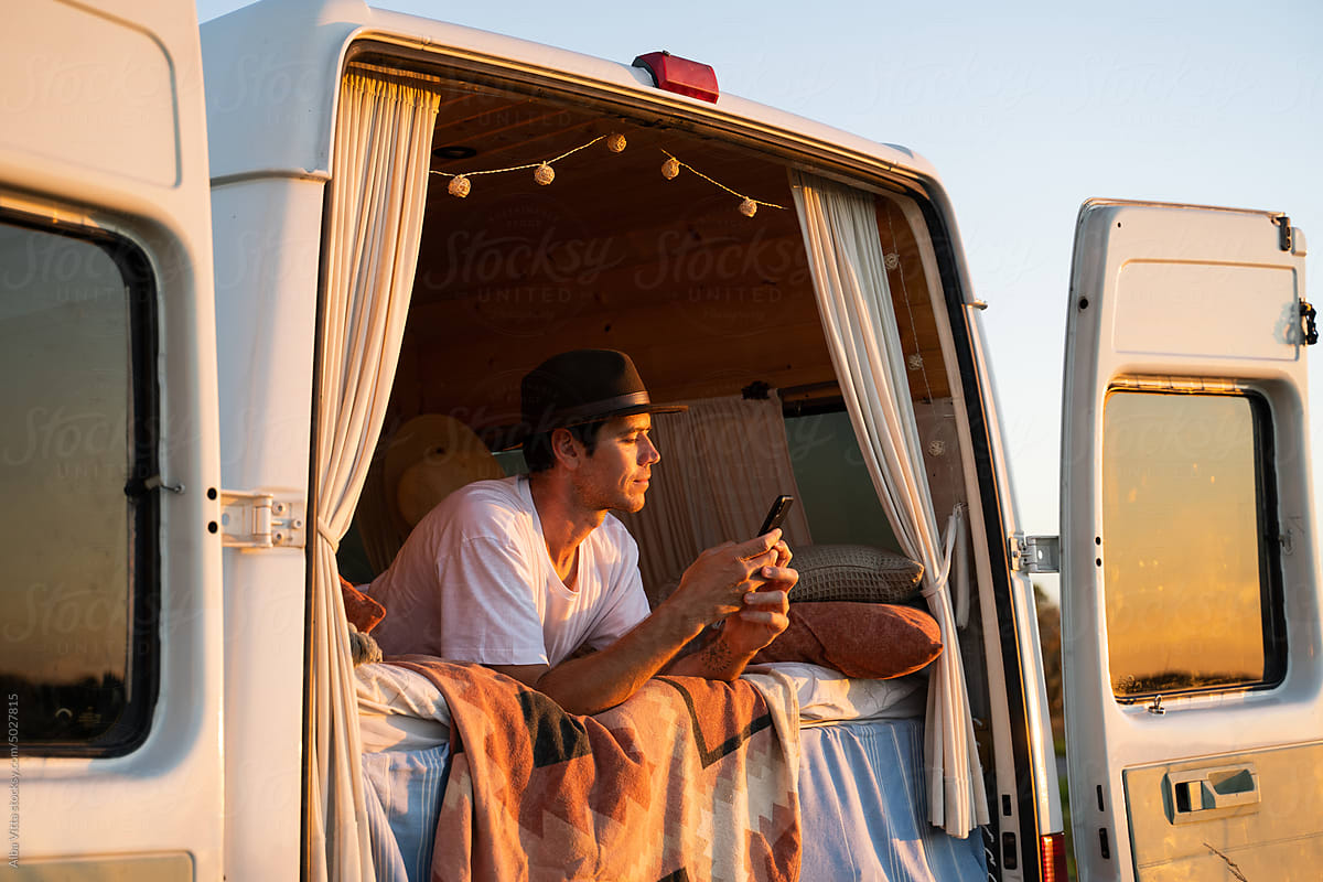 Man with phone in camper van