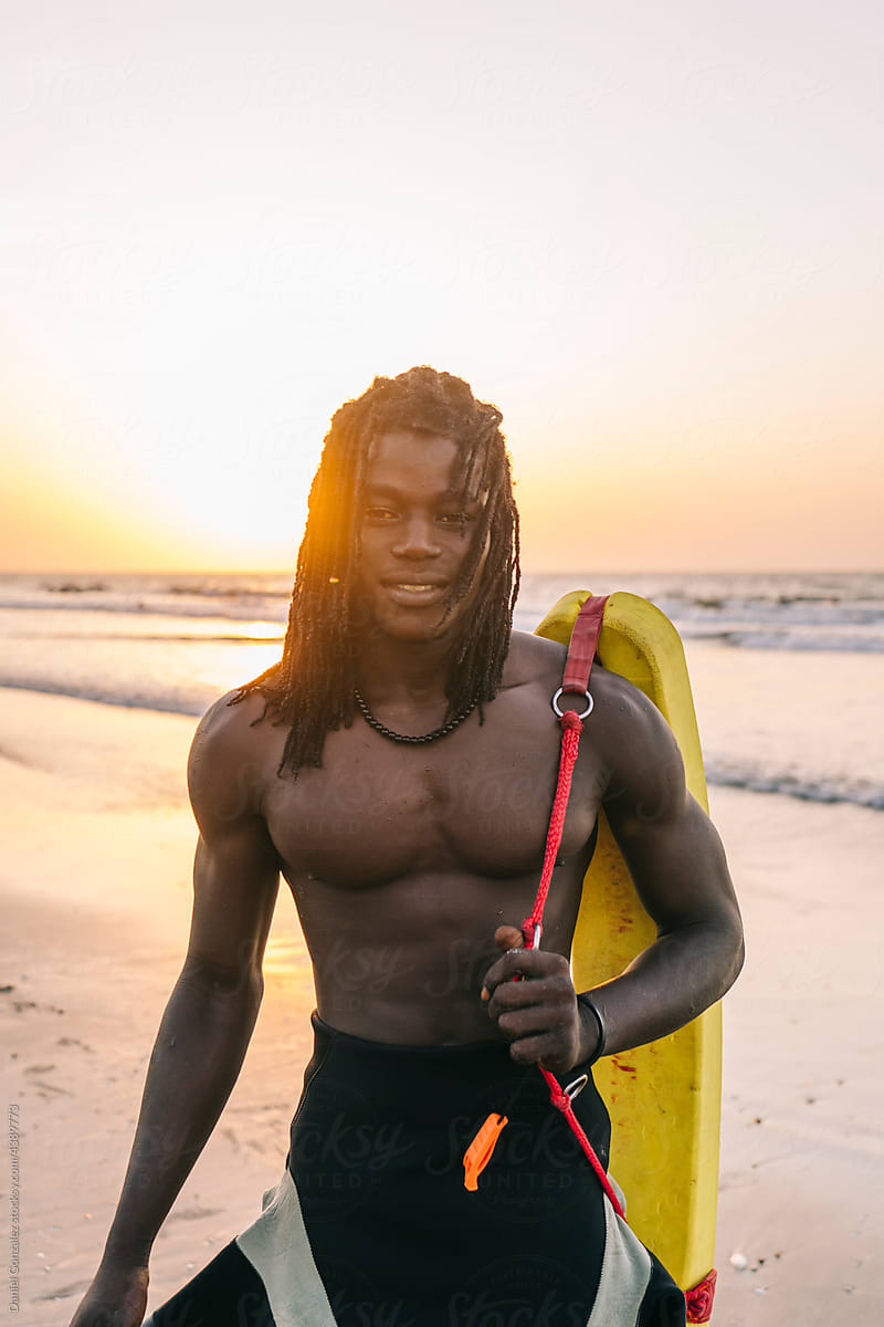 Black man with rescue tube on seashore