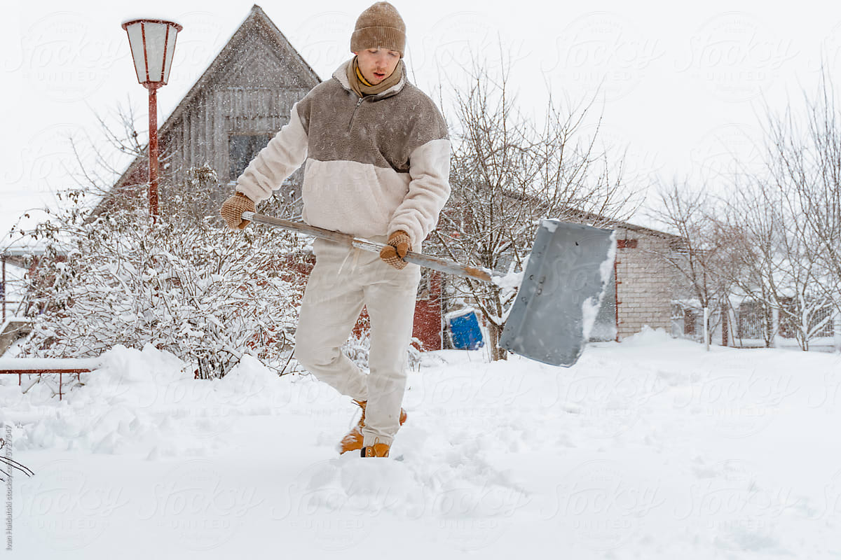 Young Man Clears Snow in Stormy Weather, Rural Chores