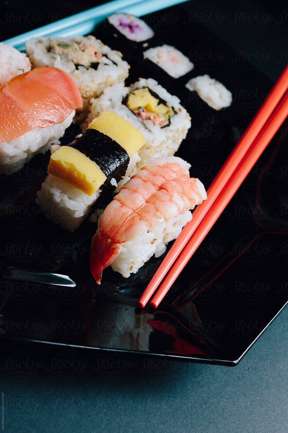 Sushi and chopsticks on black