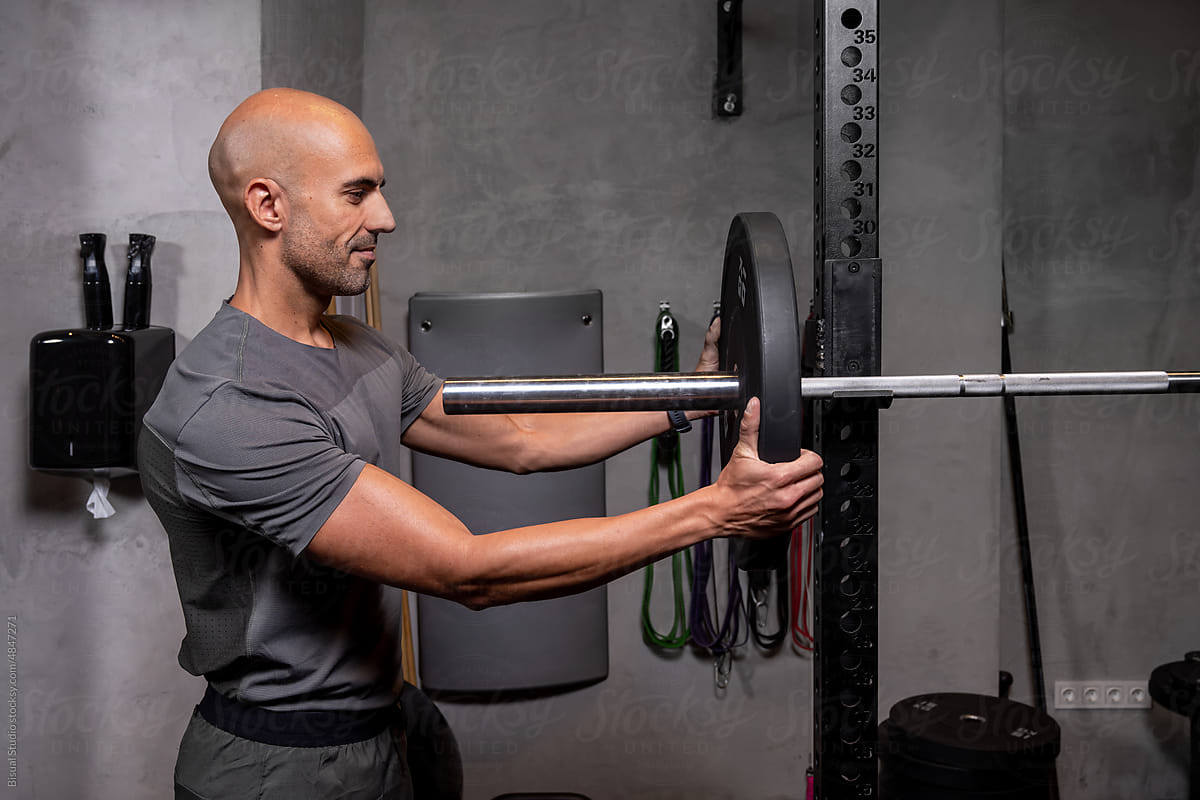 Muscular sportsman preparing for weightlifting workout