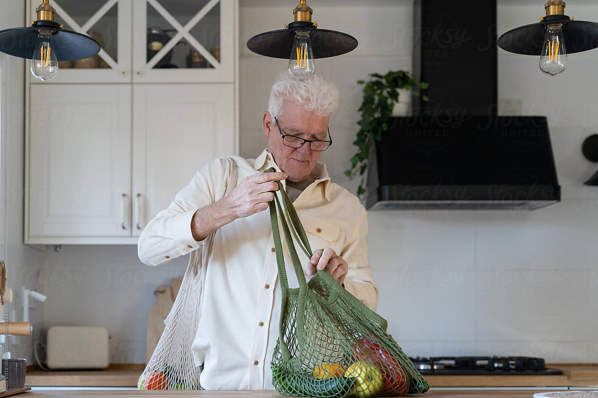 Man unpacking grocery shopping bag with vegetables